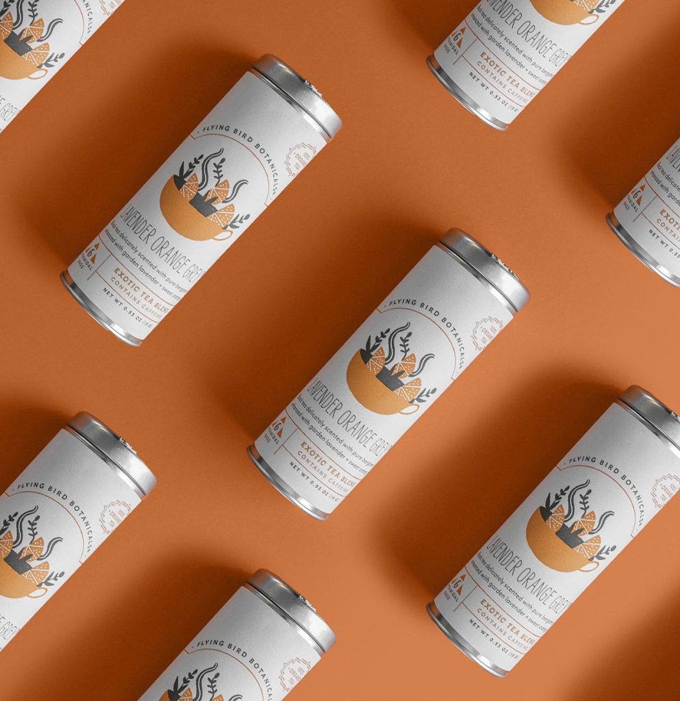 Product photography of tea tins laid out in grid pattern on orange.
