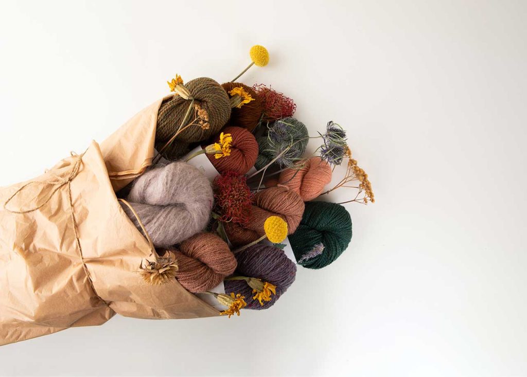 Fancy yarn product shot, wrapped up in a bouquet with wildflowers.