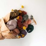Fancy yarn product shot, wrapped up in a bouquet with wildflowers.