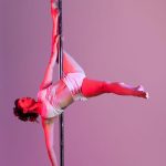 Pole dancer photoshoot with red gels on a purple and pink background.