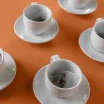 Product Photography for Flying Bird Botanical Tea of a series of teacups on an orange background with teabags in each.