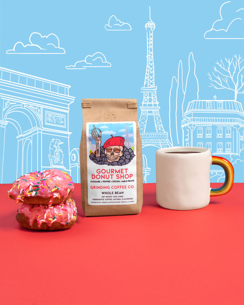 Grinding Coffee Co bag of Gourmet Donut Shop, donuts and coffee cup, with Paris illustrated on the wall behind.