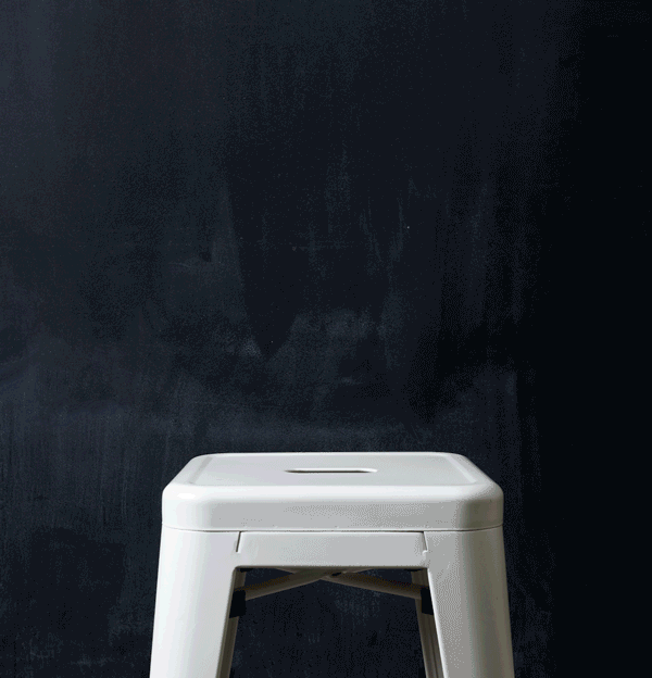 Stop motion of rainbow fabric stacking on a stool.