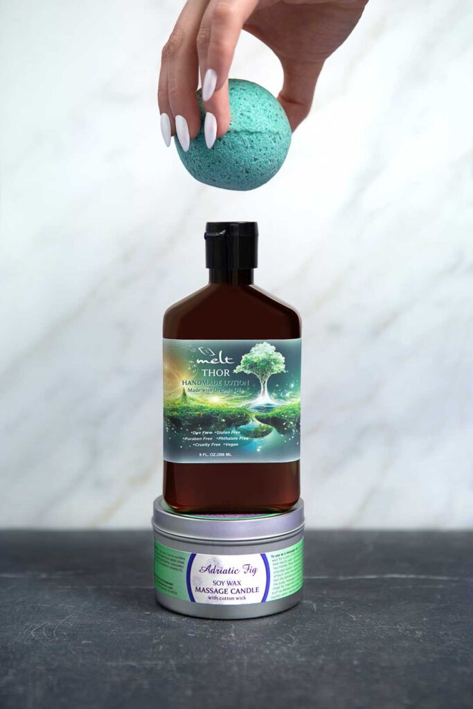 bath bomb held over lotion bottle sitting on aromatherapy candle