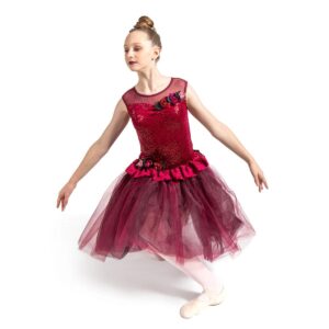 Ballet dancer in seated pose kneeling on one knee and arms pressed outward around tutu.