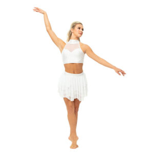 Ballet dancer in fifth position pose in elevé and arms in a diagonal, looking off camera.