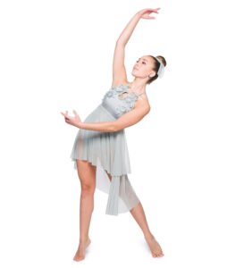 Lyrical dancer in elevé with one arm curved above and one curved forward, arching back.