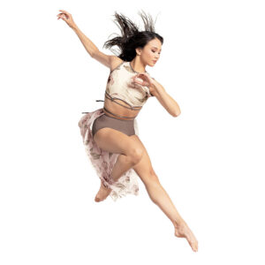 Lyrical dancer in a leaping pose, on foot tucked and arms reaching back at an angle.