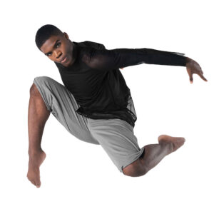 Lyrical dancer posed in a tuck leap with arms pressed back.