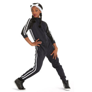 Hip hop dancer posed with one knee bent and turned in, one hand on hip and other pressed to side.