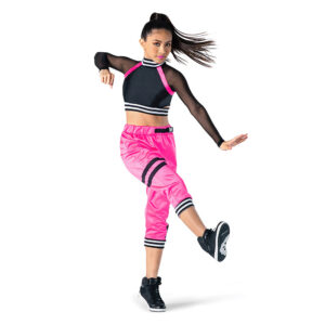 Hip hop dancer posed in elevé with one foot flexed pressing forward, one arm is flexed in front and the other is bent at the elbow with a fist.