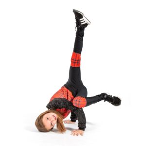 Hip hop dancer posed in a baby freeze with weight on head and hands.