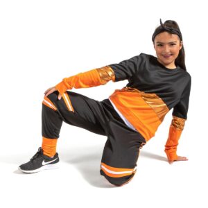 Hip hop dancer posed kneeling on the floor pressing weight back into one hand with other resting on knee.