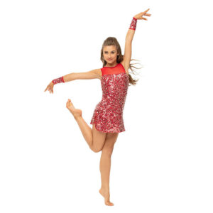 Jazz dancer posed with a flicked foot behind in elevé with one arm above head and one to the side.