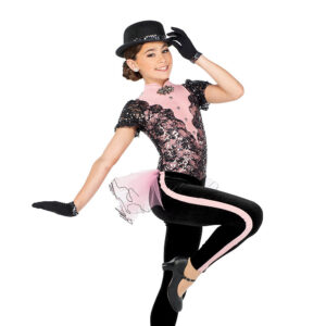 Jazz dancer posed in a passé with one hand on their hat and one flexed to the side.