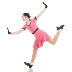 Tap dancer posed in a heel stand on one foot and the other pointed behind them, arms flexed out to the sides.