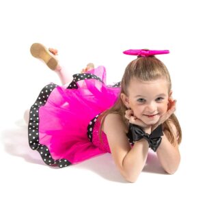 Young dancer posed on the floor laying on her tummy with her hands propped under her chin.