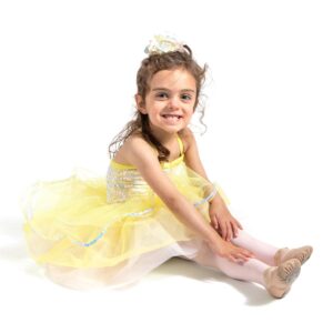 Young dancer posed seated with feet pointed in front of them and hands on knees.