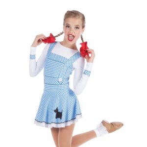 Young dancer posed with foot flicked behind them and hands holding onto braids.