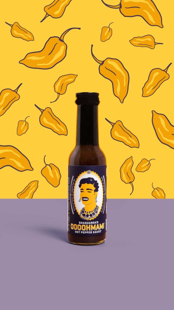 E-commerce product shot of Shaquanda's hot sauce with yellow pepper pattern illustrated behind it.
