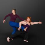 LifeArt Dance company photography of two dancers, one lunging foward and holding anothers leg as they reach back.