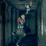 Photo composite of a tap dancer from Rocky Mountain Rhythm posed in a tuck jump as the undead in a dark dirty hallway scene.