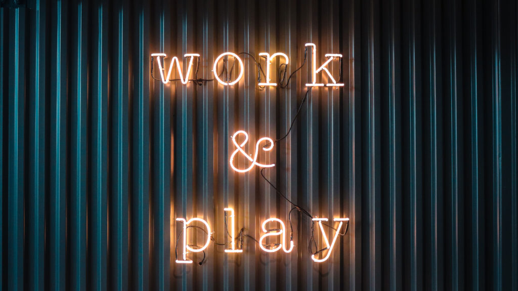 Neon sign that says "work and play".