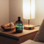 Photo composite of lotion bottle from Melt on bedside table in warm lighting.