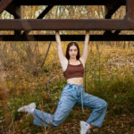 Dancer hanging off a bridge in a stag pose