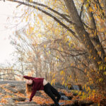 Dancer doing an arch on rocks in a waterfall