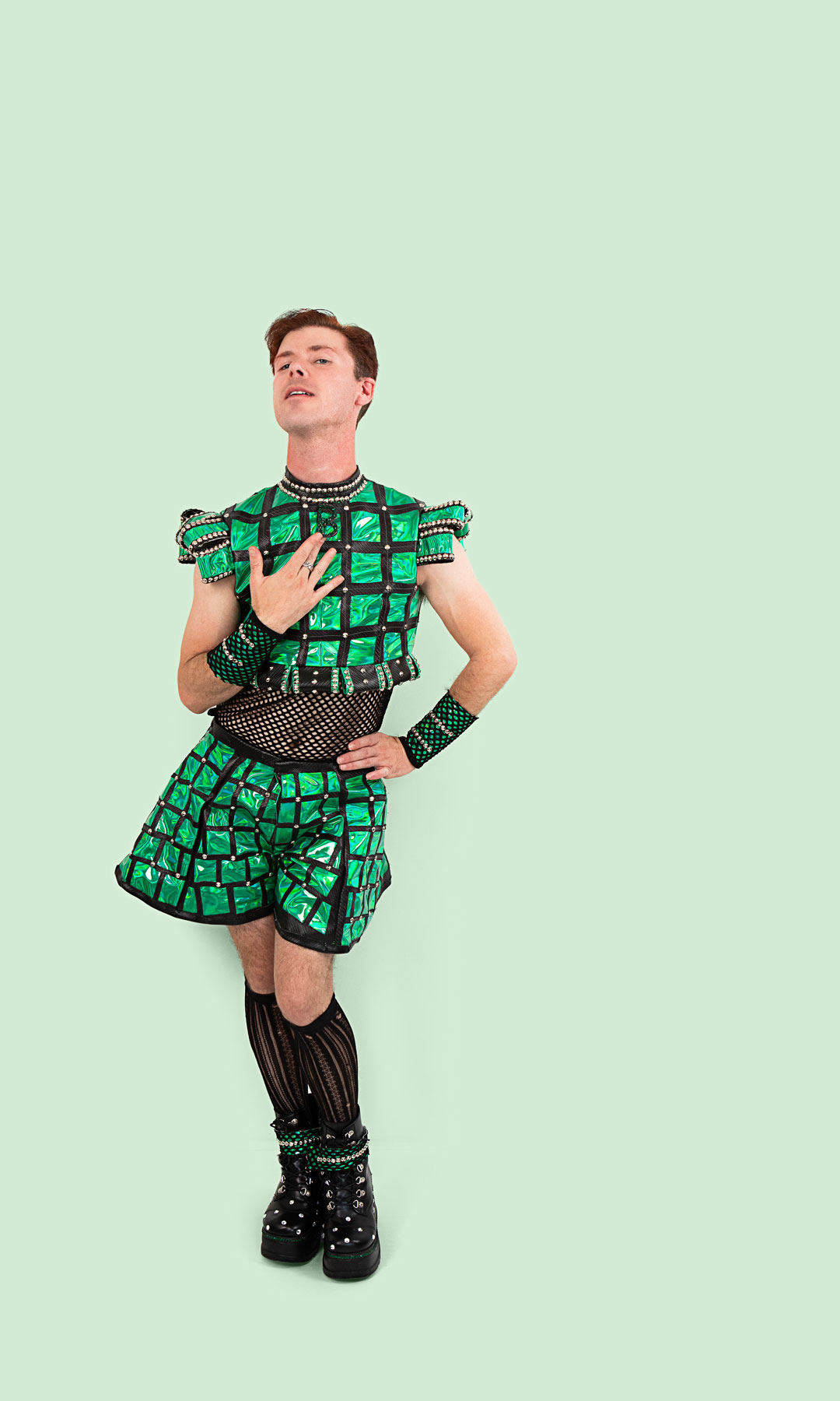 Male dancer in Anne Bolin-inspired costume posed with his hand to his neckline