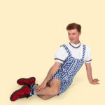 Male dancer in Dorothy-inspired costume posed on the floor