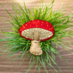 Felt kit of mushroom laying on grass background