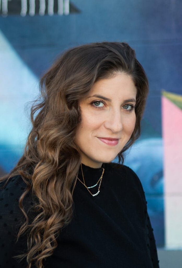 Headshot of Jari in front of an art mural in Denver