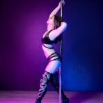 Pole dancer in an arched stance on the pole