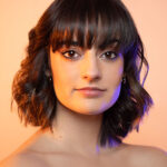 Headshot of MJ with gel lights highlighting the side of her face