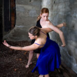 Dancers in curved poses wrapped around each other in an outdoor scene