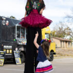 Stilts performer interacting with a child at the event