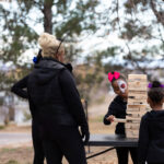 Family with face paintings playing Jenga at the event