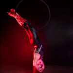 Lyra dancer posed balancing without arms on hoop