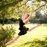 Dancer leaping in front of a rose garden