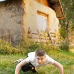 Dancer arched forward on the floor at a farm