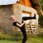 Dancer doing a bent leg hold at a farm