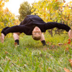 Dancer in a full backward arch in the middle of a vineyard