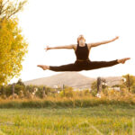 Dancer in a split leap with a mountain scape behind