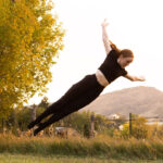 Dancer leaping to the side with a mountain scape behind