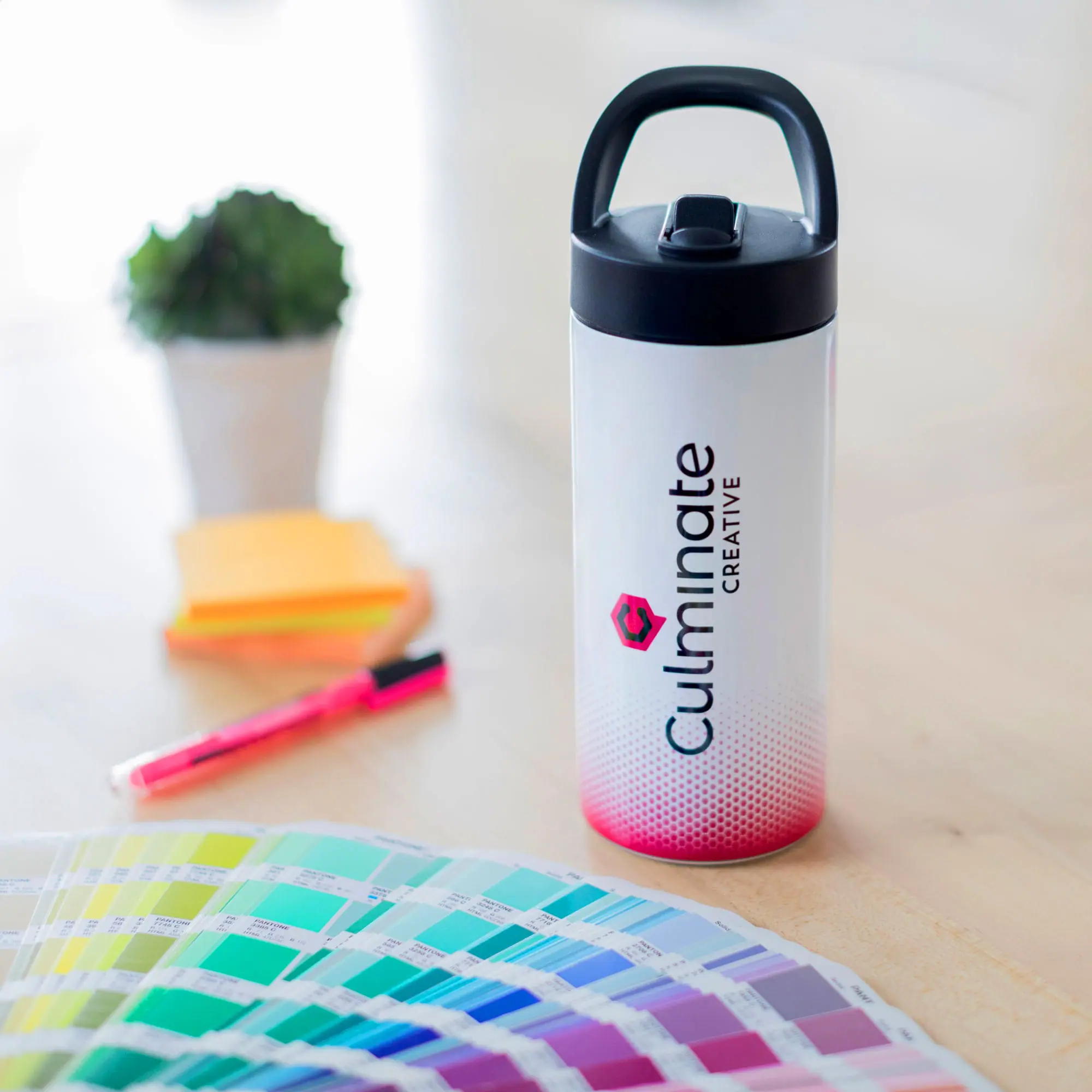 Bright white water bottle with black lid and "Cullinate Creative" logo on printed on it.