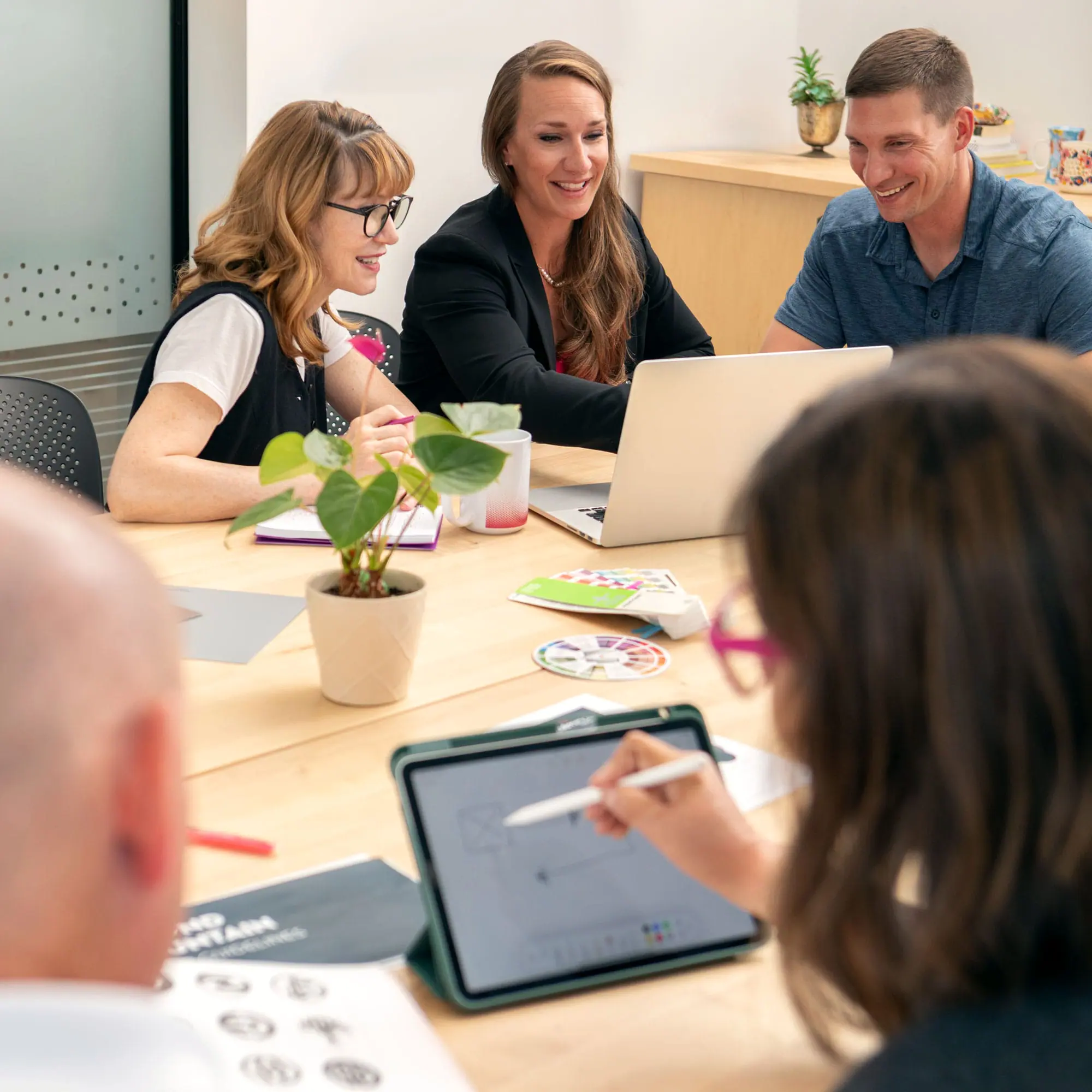 Bright professional team collaborating at a creative design meeting in an office.