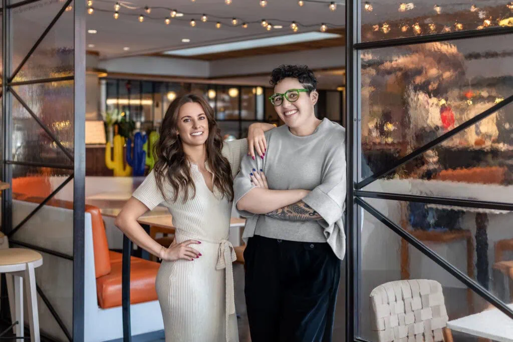 Vibrant women entrepreneurs at Andrews Artistry, showcasing confidence and teamwork in a modern, artistic workspace.