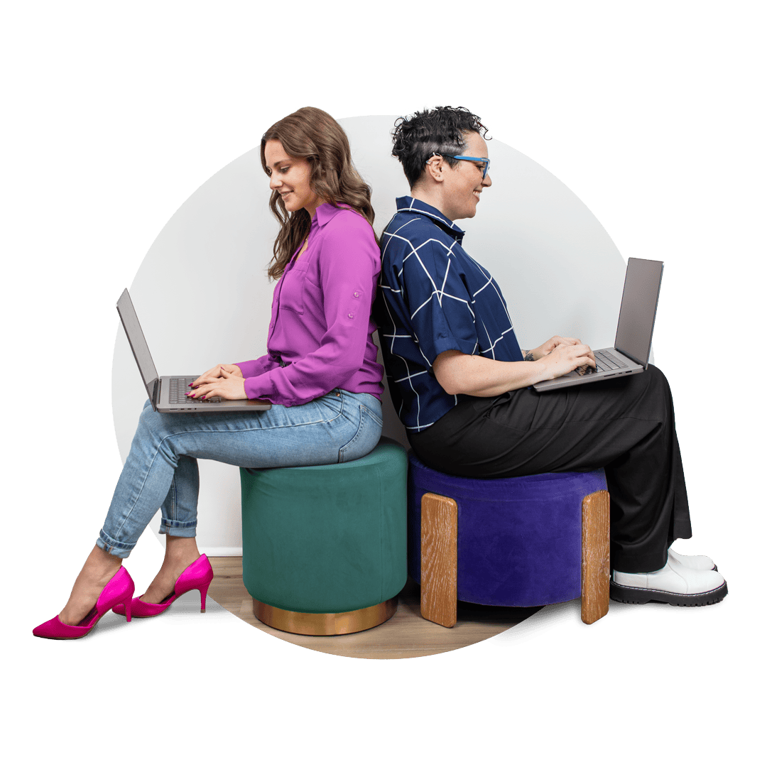 Laptop users sitting back to back for digital collaboration and creative teamwork.